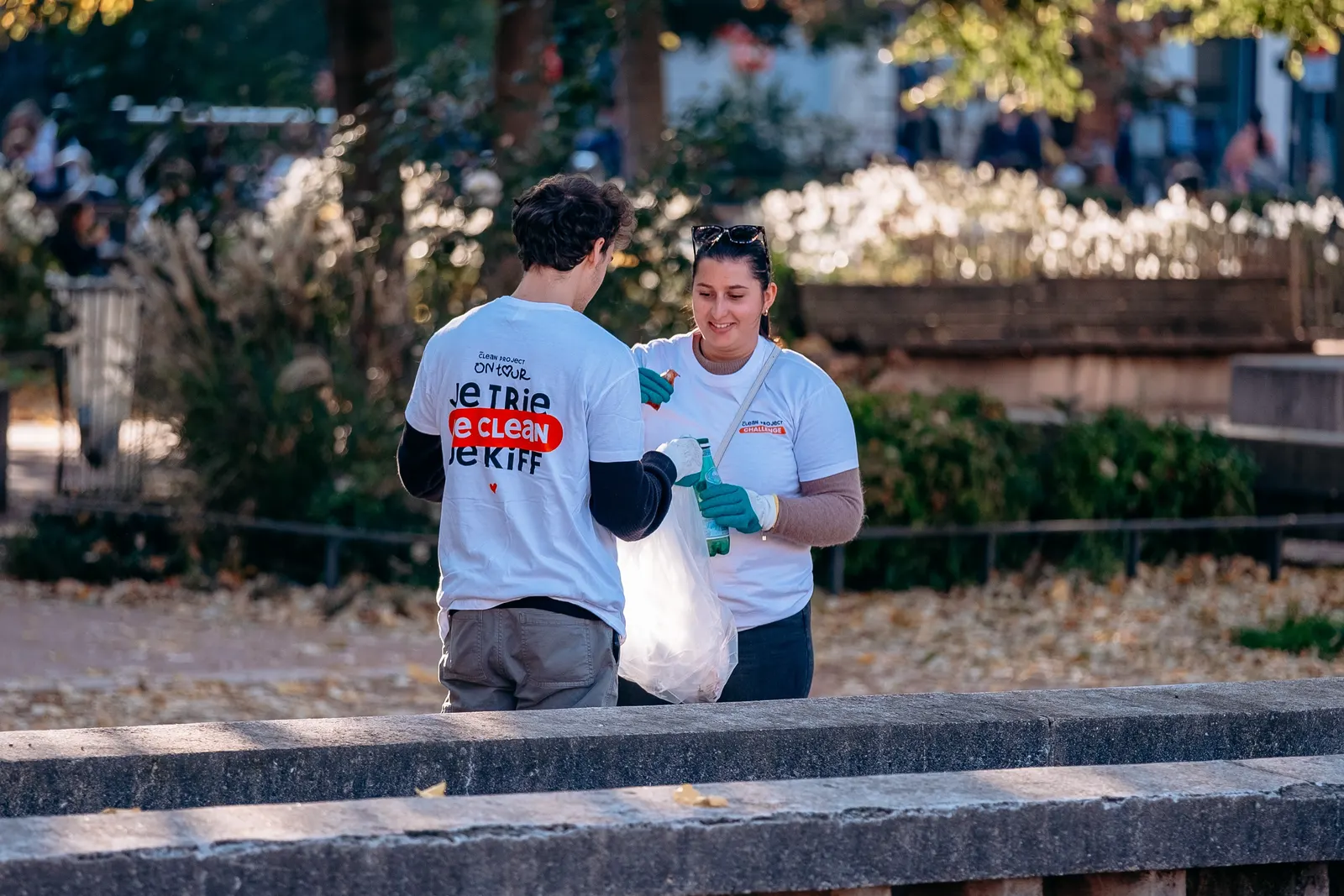 Deux bénévoles en t-shirt Je trie, je clean, je kiff trient leur collecte
