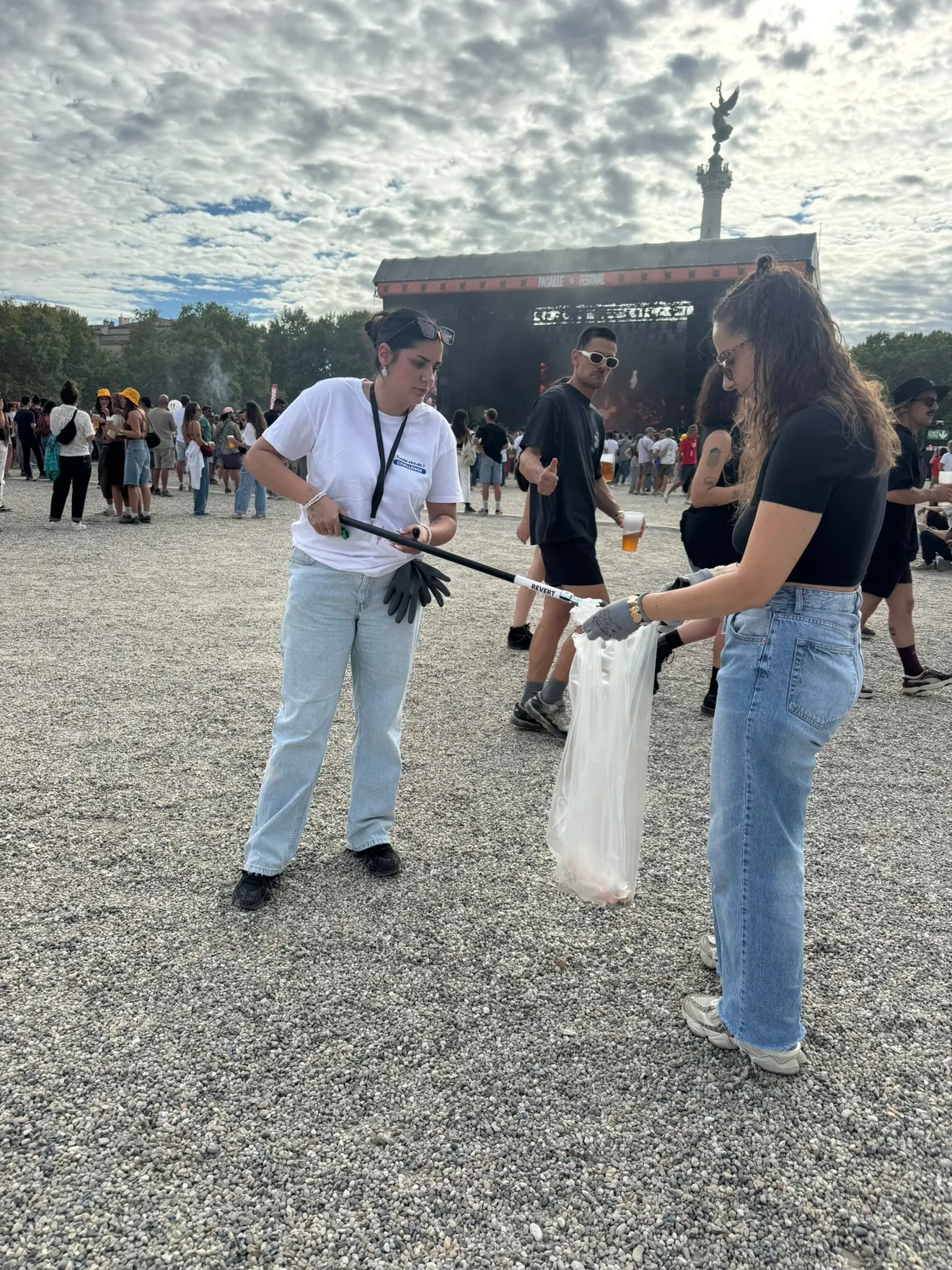 Une bénévole ramasse les déchets devant la grande scène du festival Pagaille