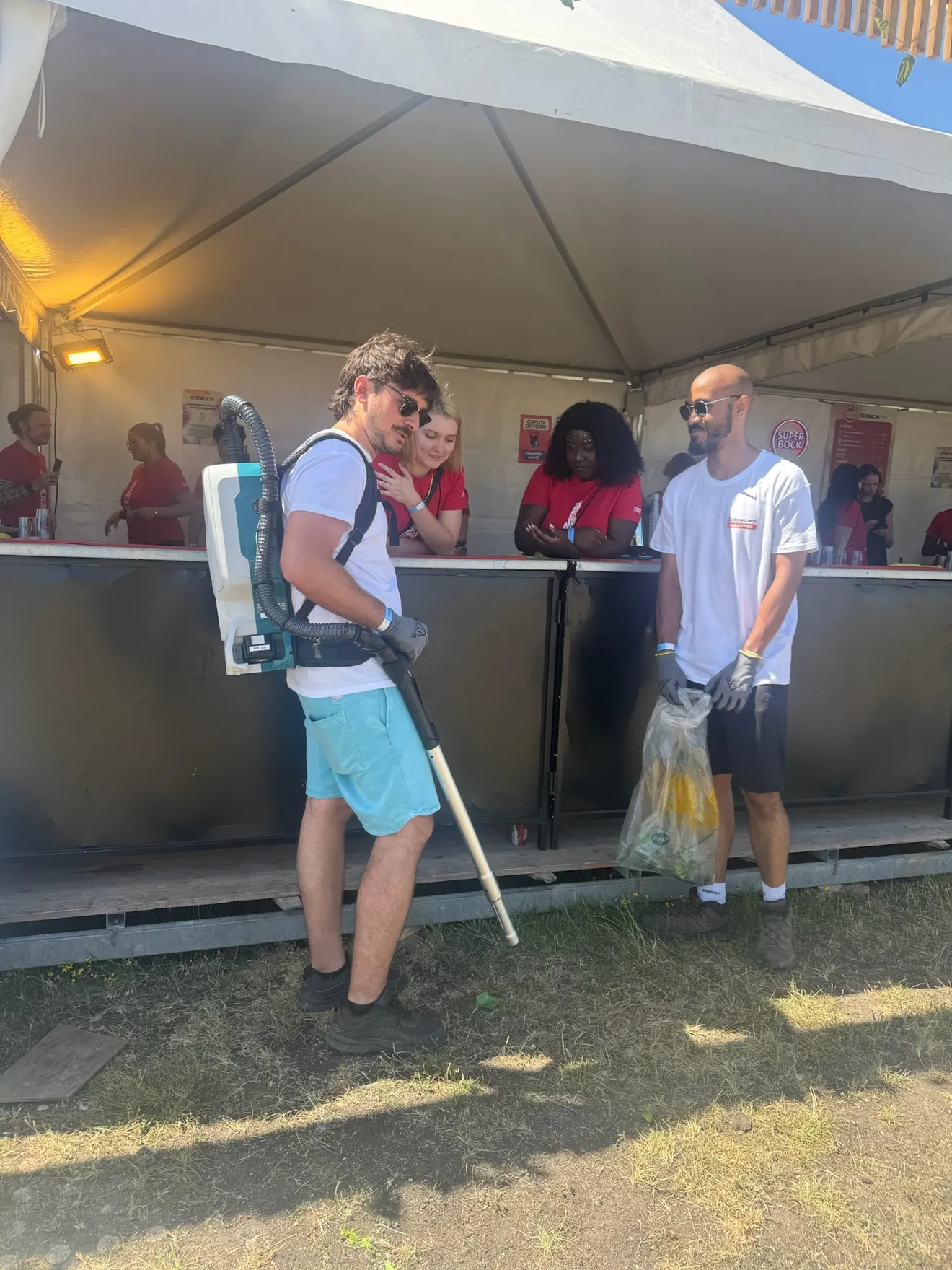 La brigade passe devant un bar, avec les équipes du festival