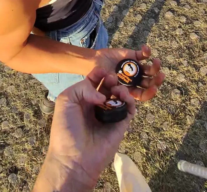 Un animateur remet un cendrier de poche à une festivalière