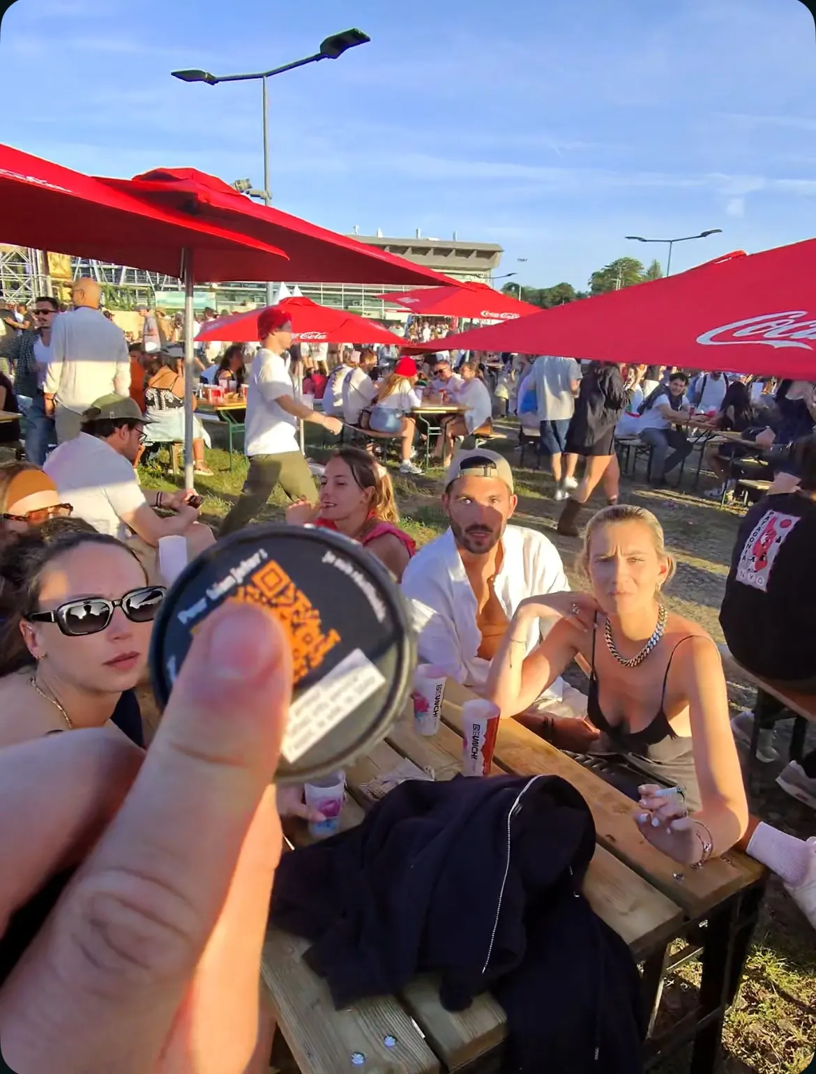 Un animateur tend un cendrier de poche à une table de festivaliers