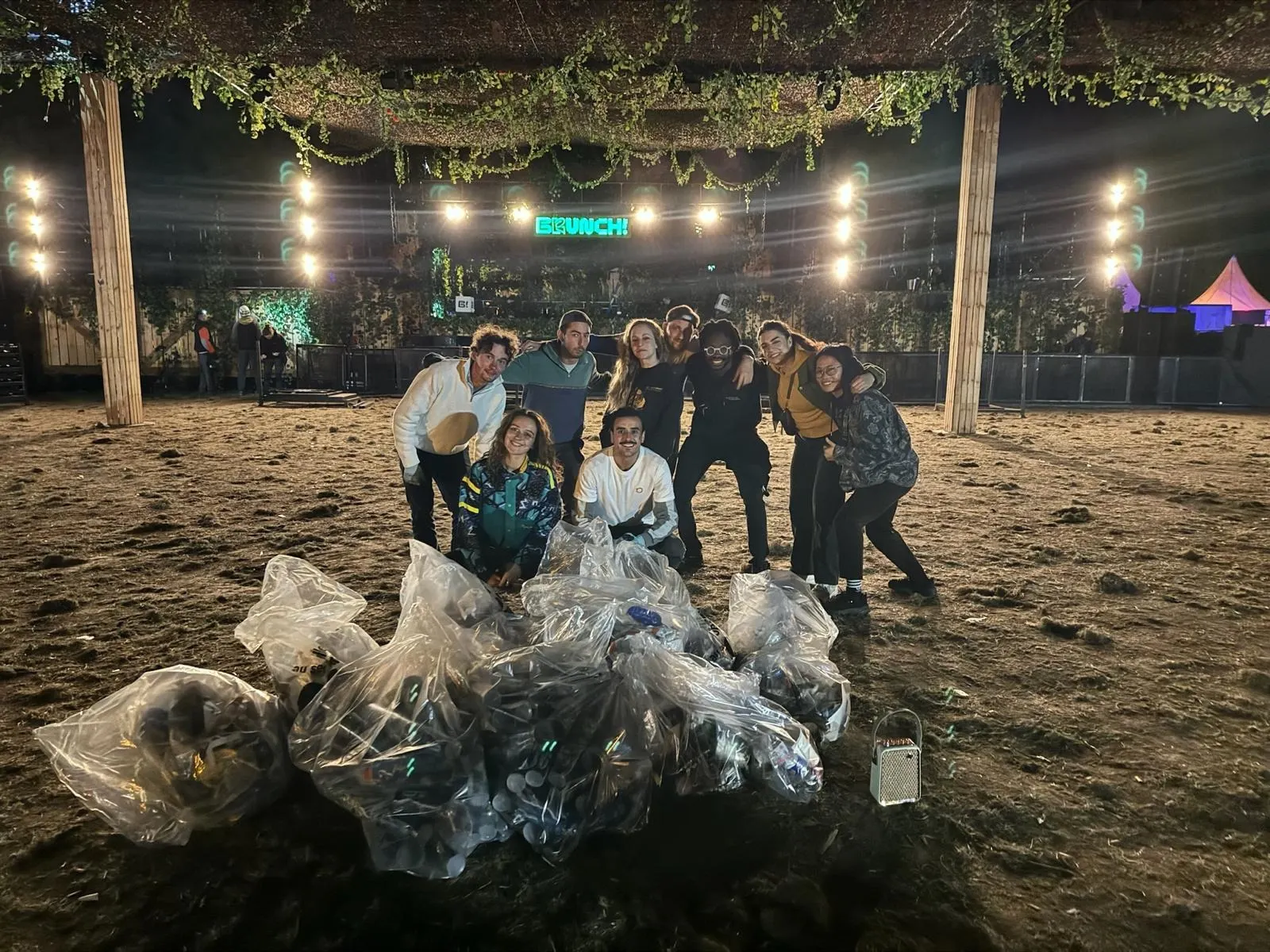 La brigade de nuit pose avec ses sacs devant la scène Brunch