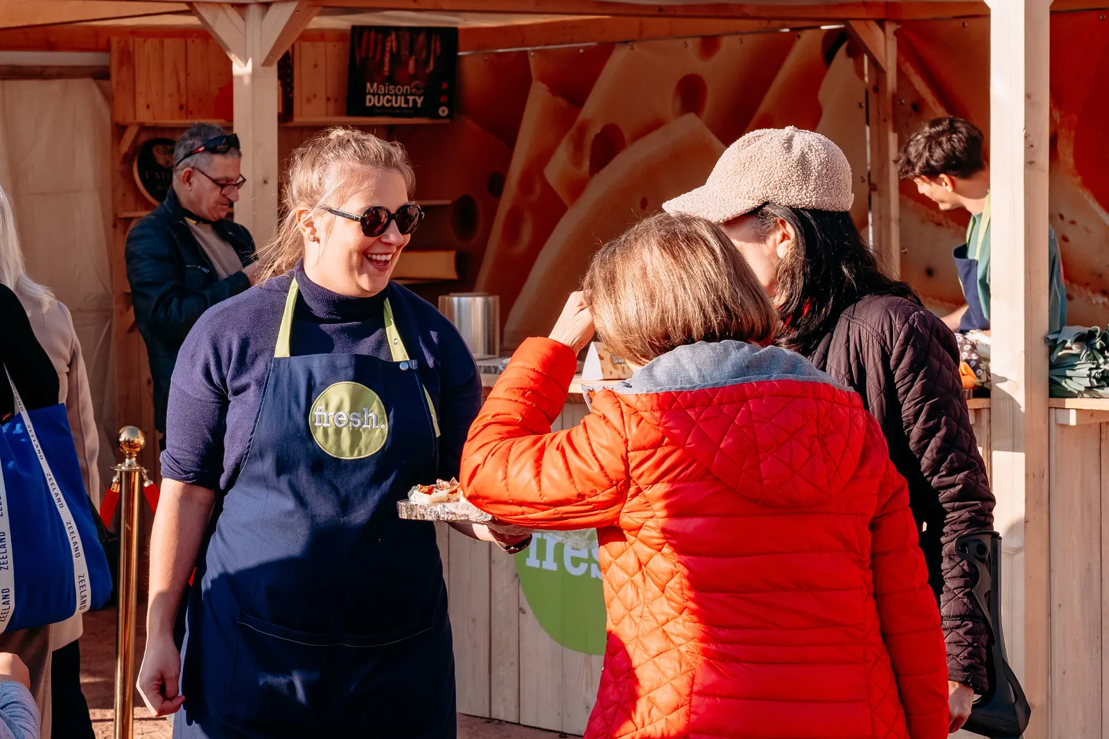 Une salariée Fresh fait goûter les produits à des visiteuses