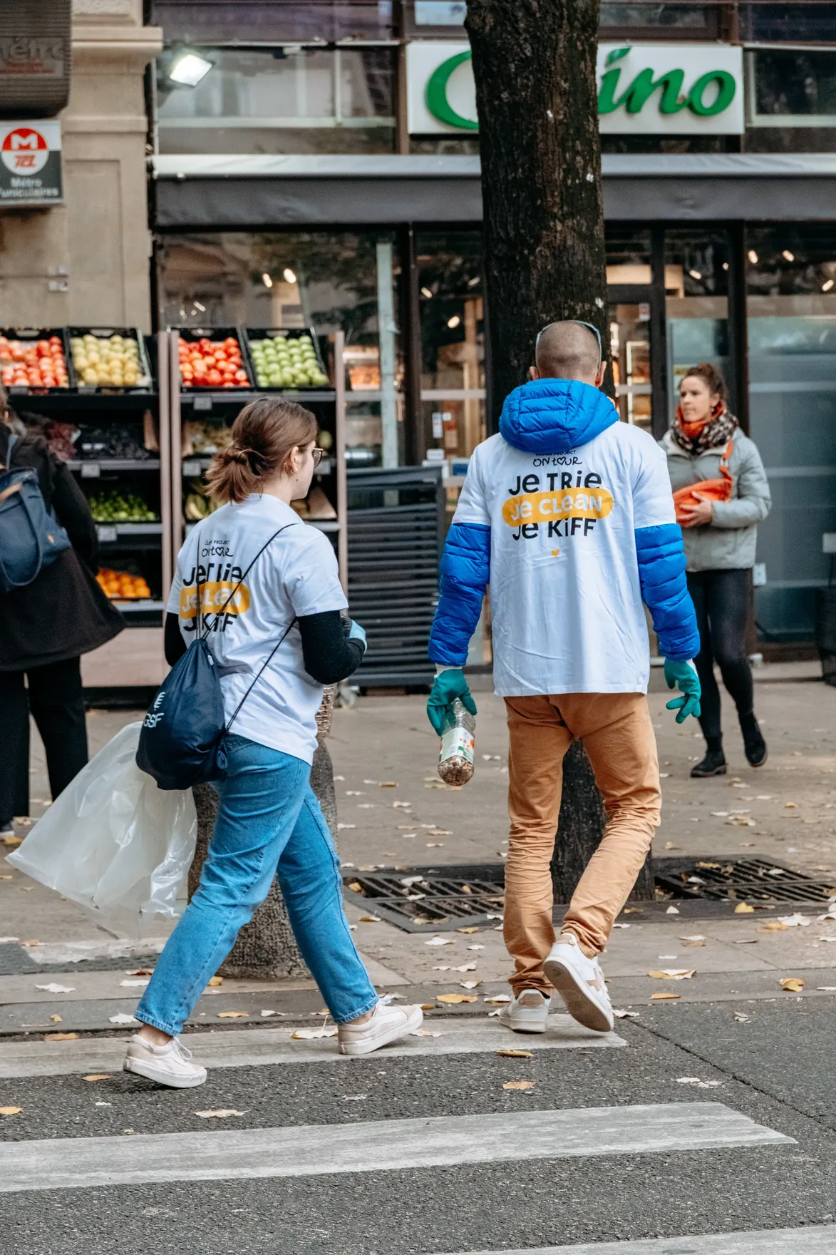 Deux participants traversent la rue avec leurs sacs et une bouteille de mégots