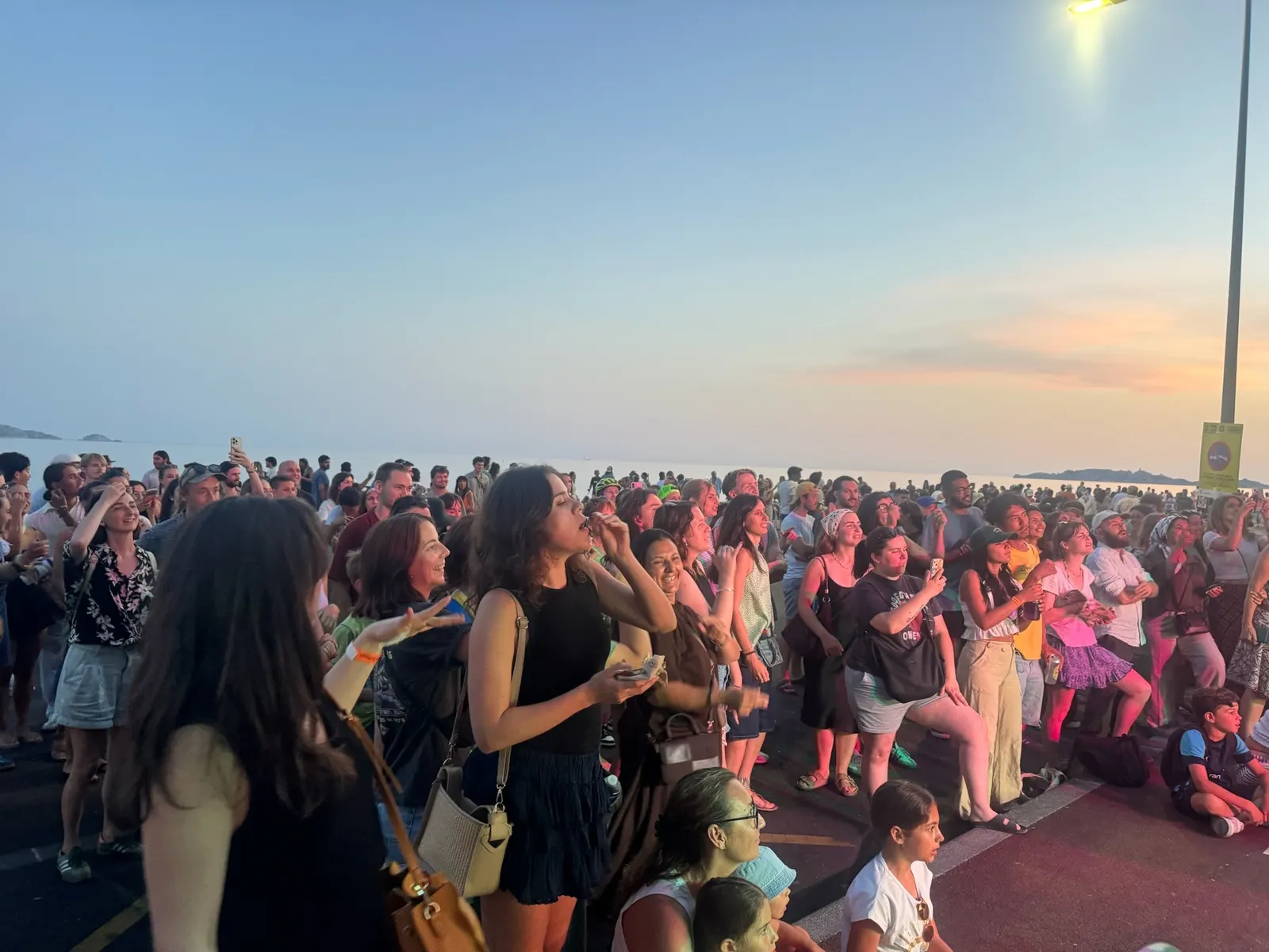 La foule chante au coucher du soleil sur la Corniche
