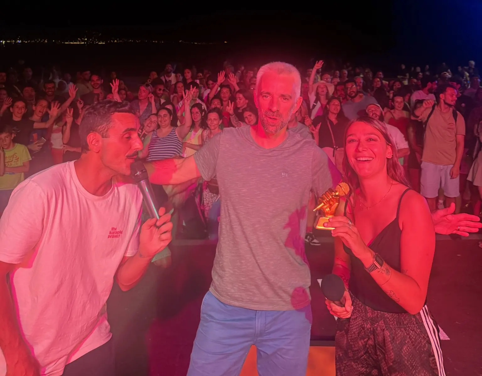 La gagnante du Micro d’Or avec son trophée, devant le public, à la nuit tombée