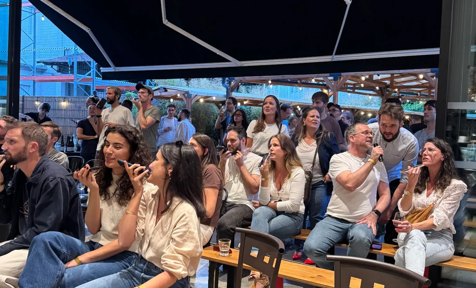 Des salariés chantent dans leur téléphone pendant une soirée d’entreprise