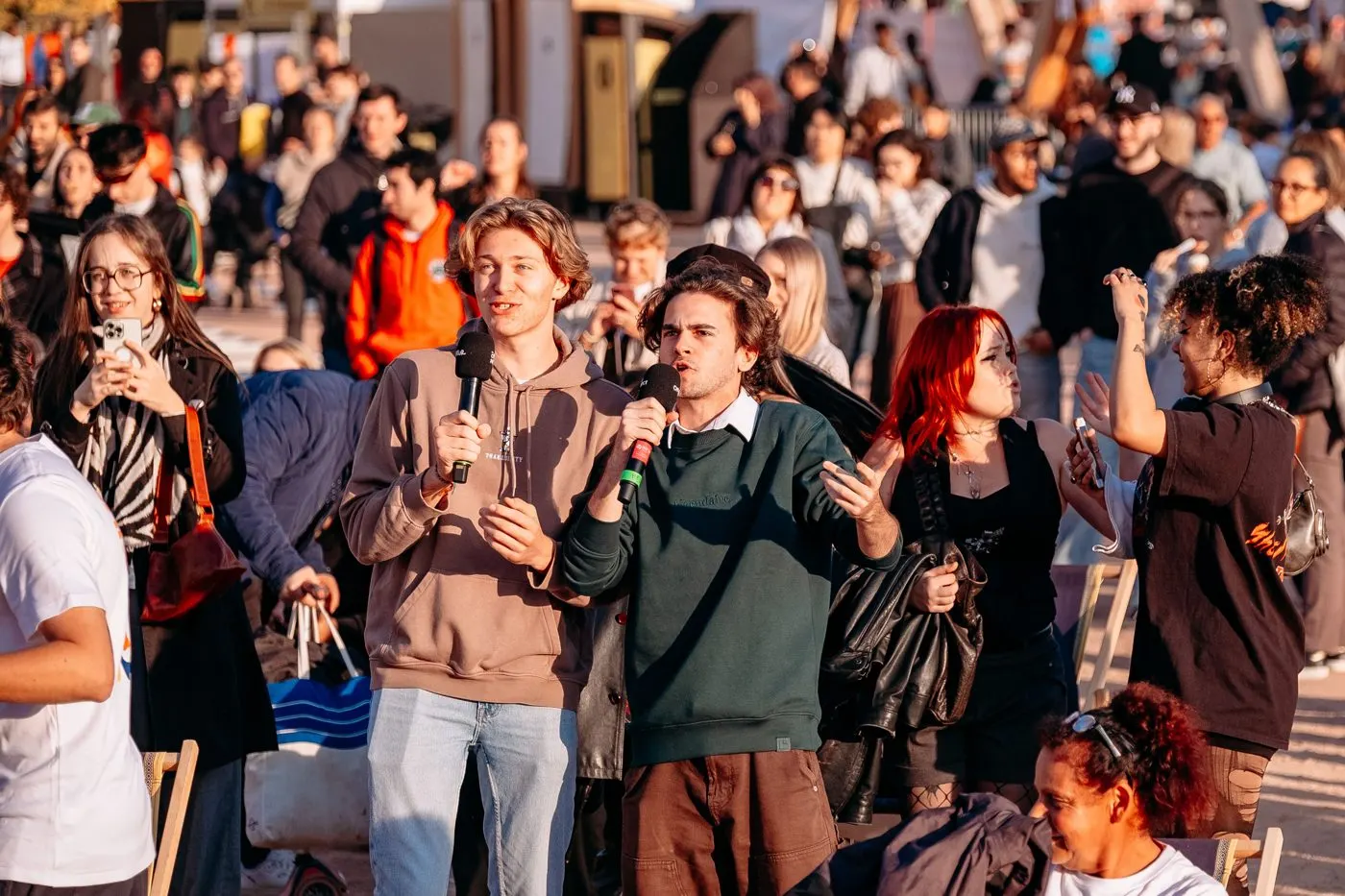 Des participants chantent au micro au milieu du public