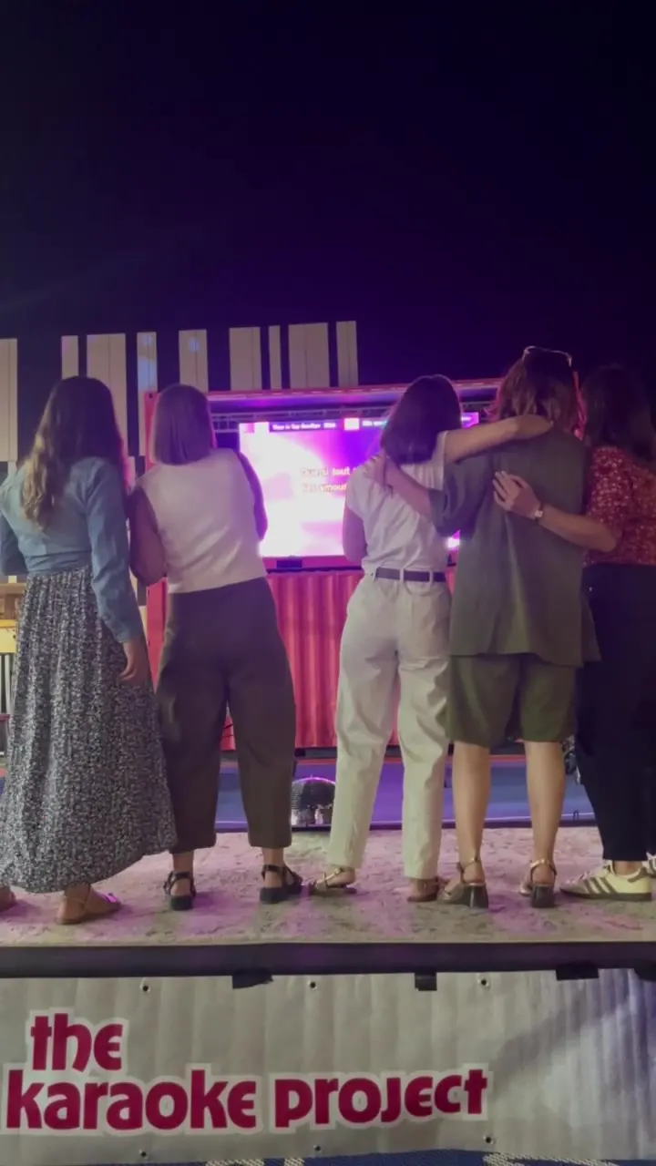 Un groupe d’amies chante face à l’écran des paroles